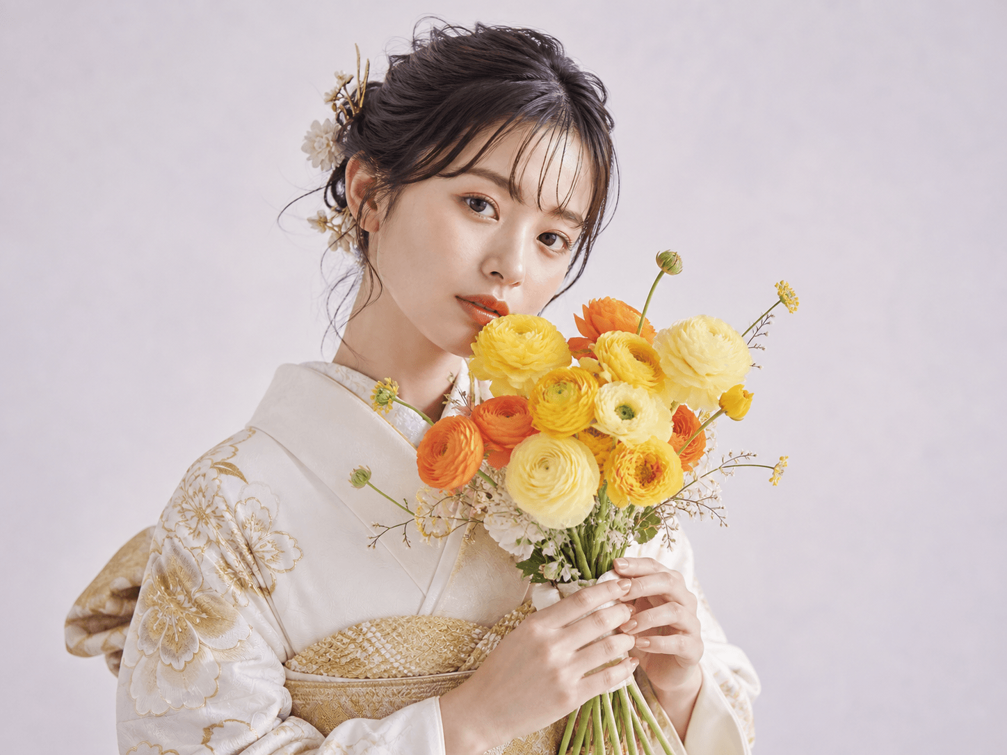 白い振袖を着て花束を持つ女性